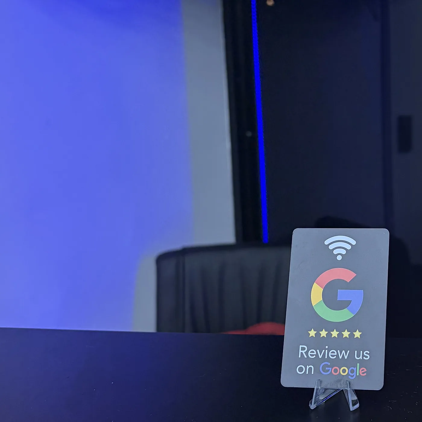 Tarjeta UNTAP en el mostrador de Elite Barber Studio, con luz azul de fondo