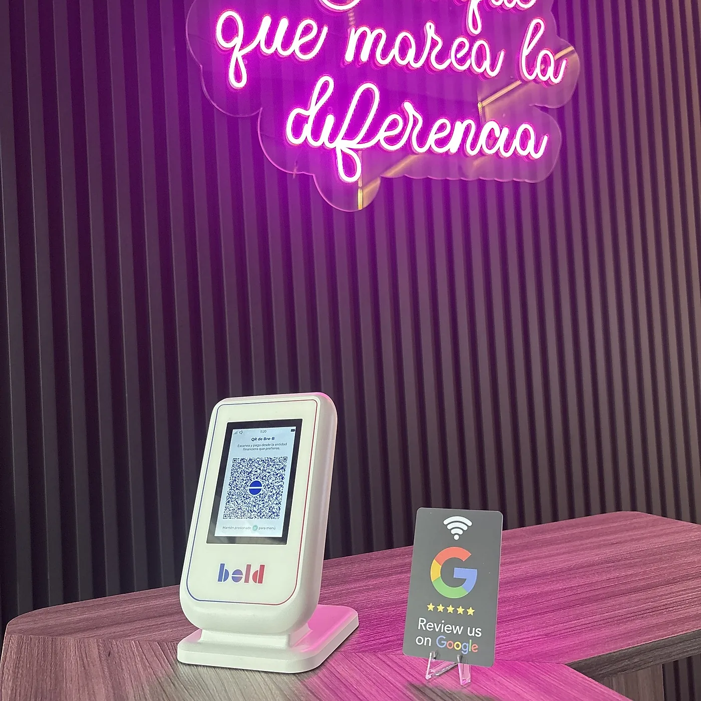 Tarjeta UNTAP en el mostrador de El Toque Barber Shop, junto al aviso de neón